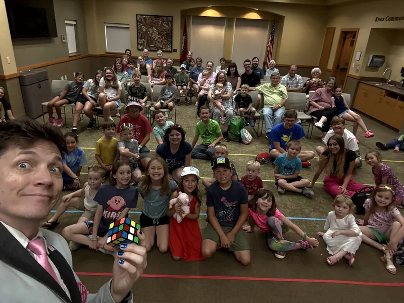Joe Coover taking a selfie with a library audience of kids and families